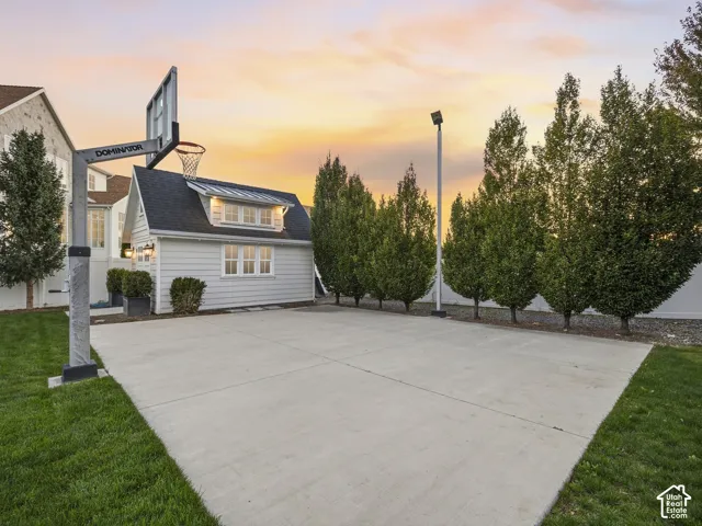 Paved sport court with an adjustable basketball hoop