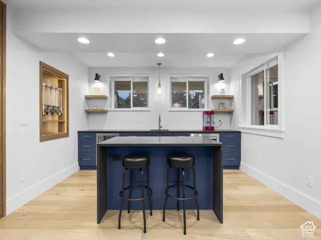 Contemporary kitchen with wood-finish flooring, recessed lighting, and a built-in beverage refrigerator