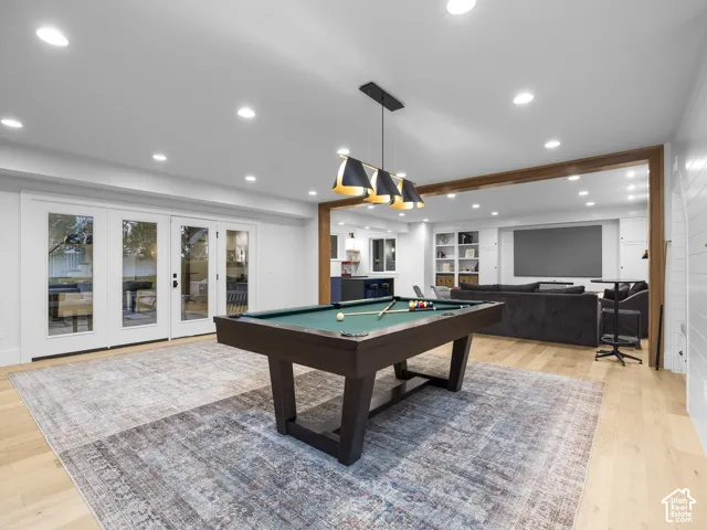 Bright room with recessed lighting, wood-finish flooring, and white French doors