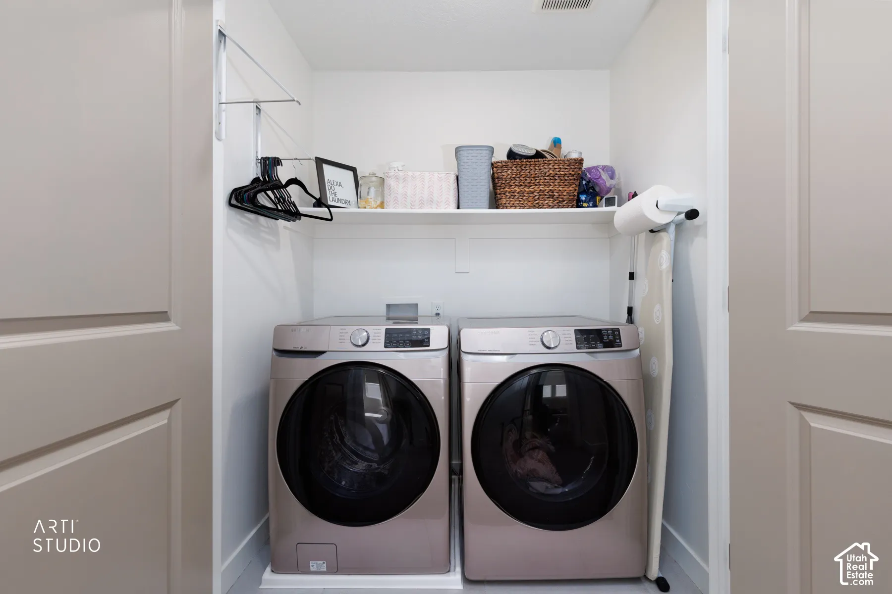 Recessed laundry area featuring built-in shelving, a retractable drying rack, and space for side-by-side appliances