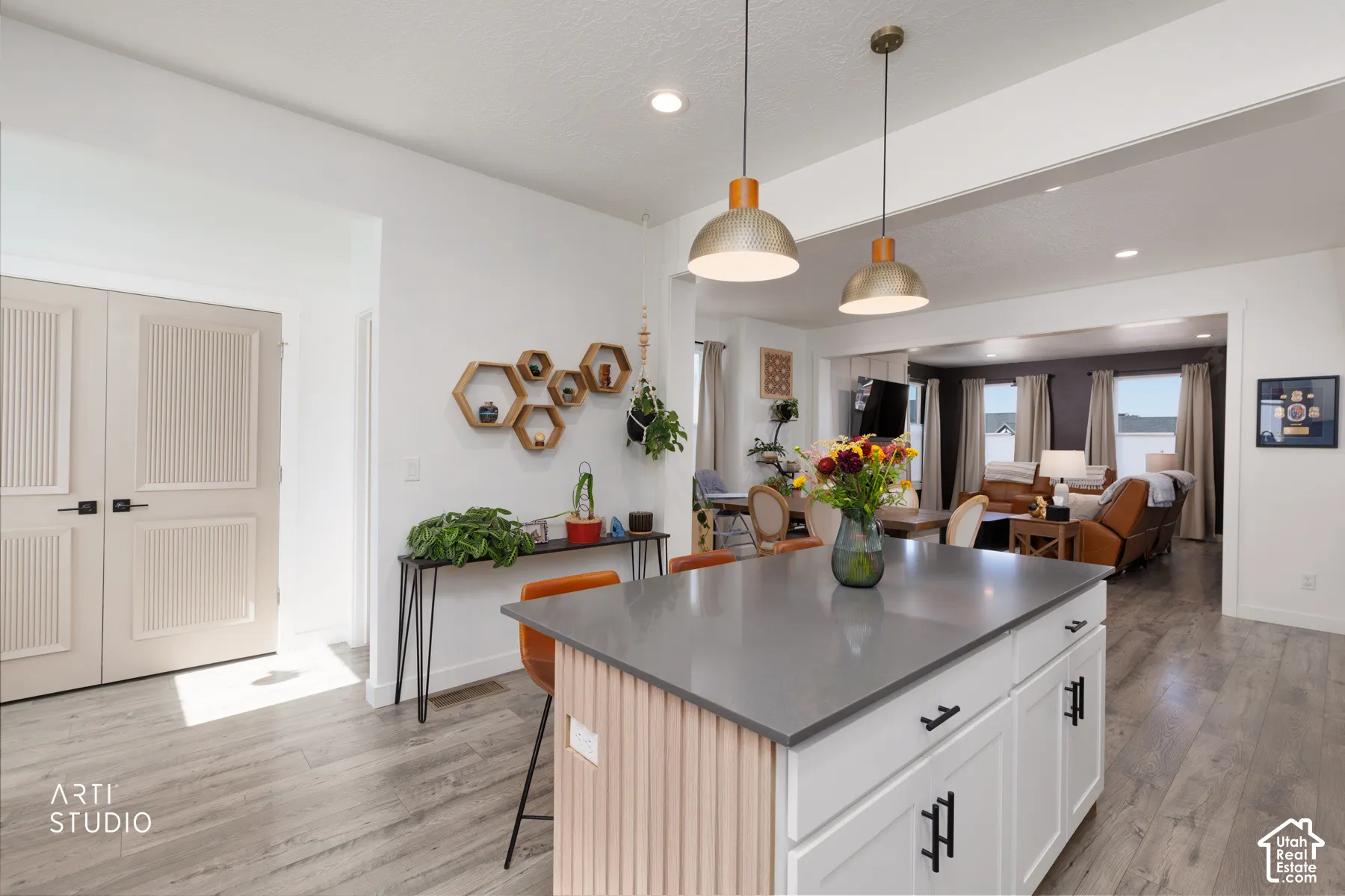 Central kitchen island with a grey countertop and white cabinetry