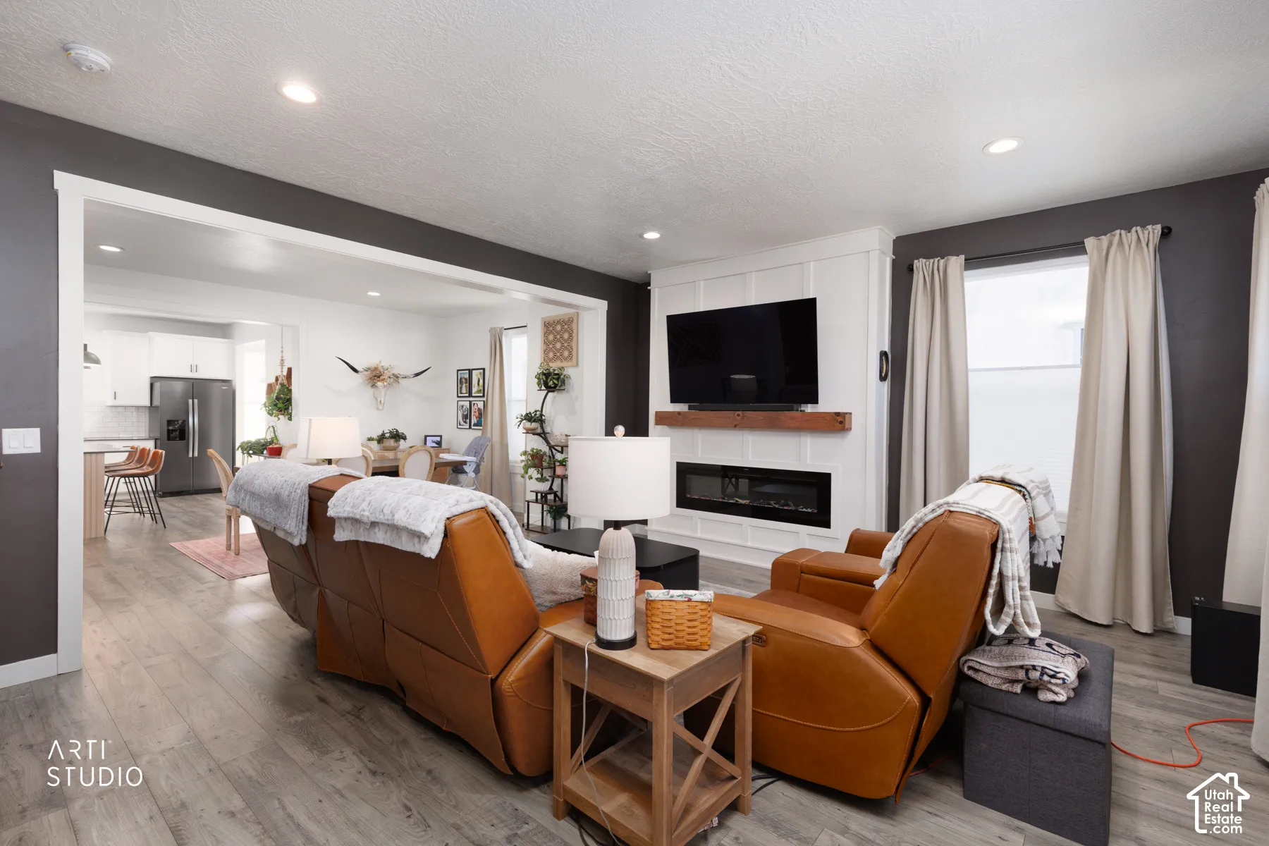 Wood-finish flooring, recessed lighting, and a built-in fireplace with a wood mantle