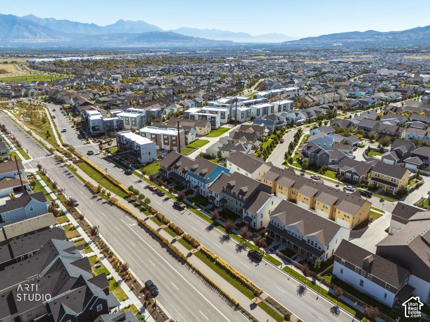 Aerial perspective of residential community with various housing styles and mountain backdrop