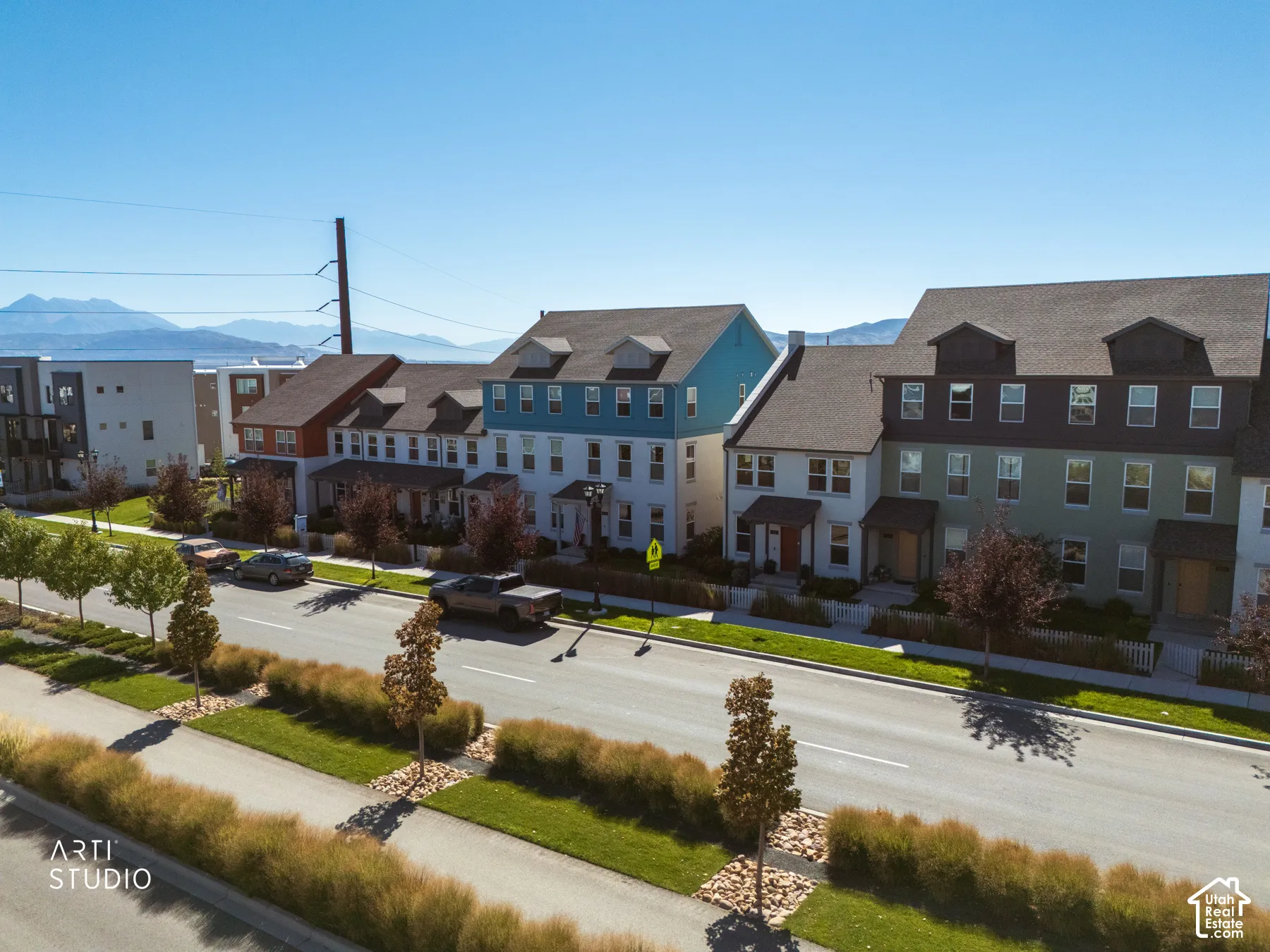Row of multi-story townhomes with dormer windows and varied exterior finishes