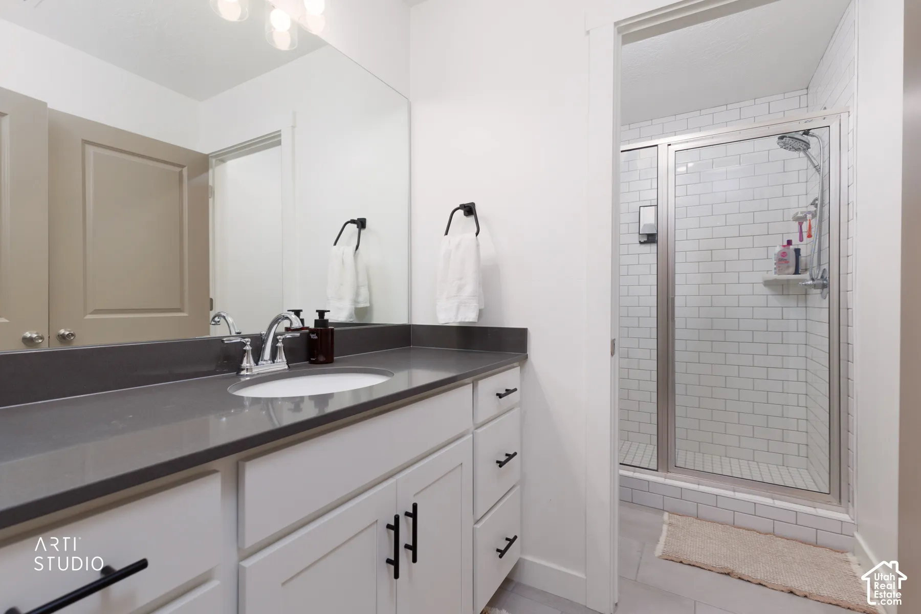 White vanity with dark countertop and undermount sink