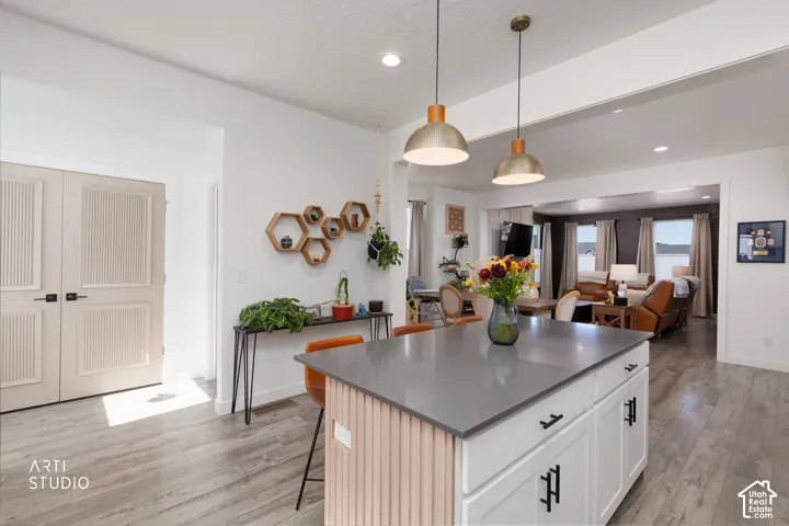 Central kitchen island with a grey countertop and white cabinetry