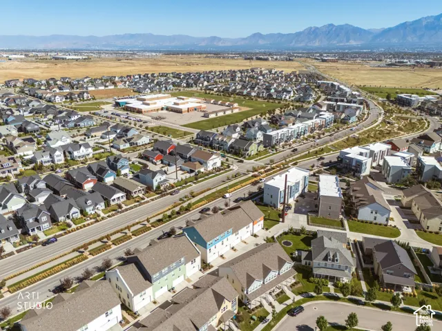 Expansive residential development with a variety of architectural styles, mountainous backdrop, a central community building, and established roadways
