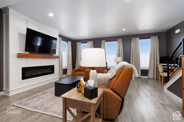 Living area with wood-finish flooring and multiple windows