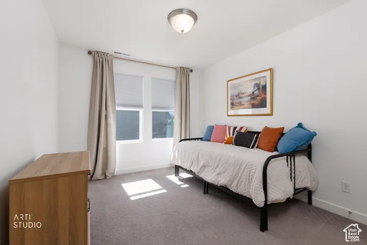 Dual windows with cellular blinds and drapery rods, flush mount ceiling light, and light gray wall-to-wall carpeting