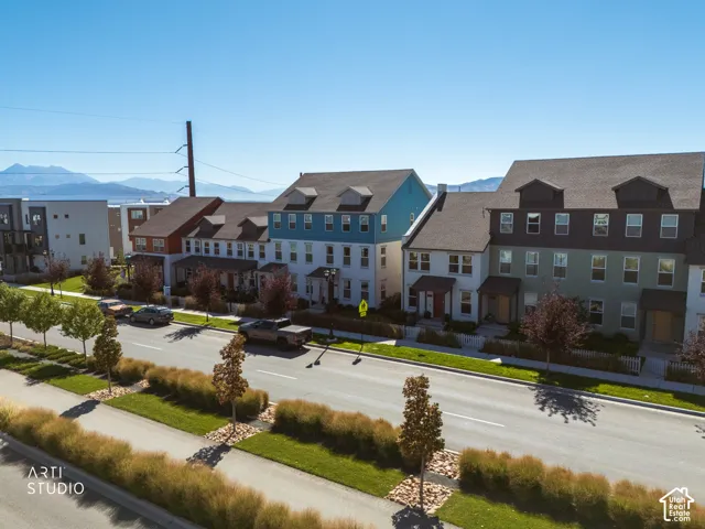 Row of multi-story townhomes with dormer windows and varied exterior finishes