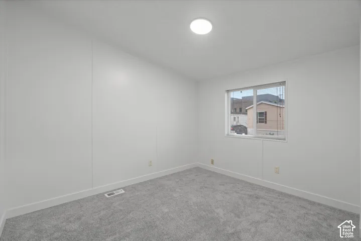 Bedroom #3 Bright room featuring light grey carpet flooring, white walls, a white trim package, and a flush-mount ceiling light
