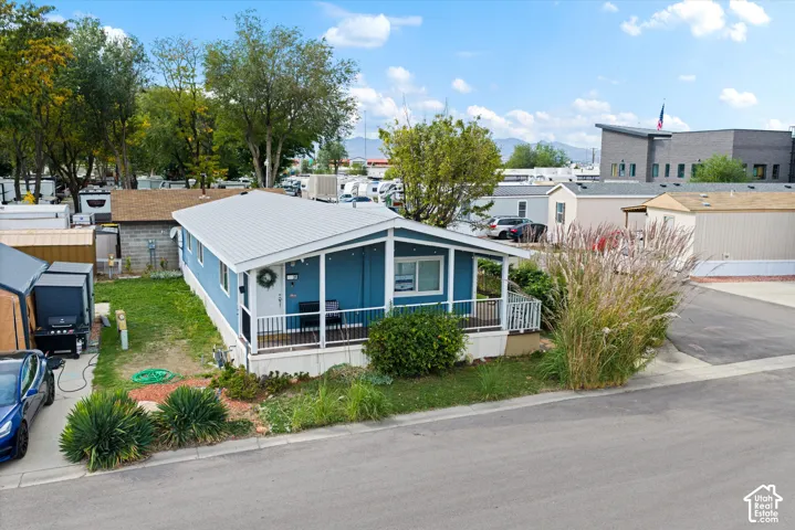 Blue exterior with a light-colored metal roof and a covered porch featuring white railings