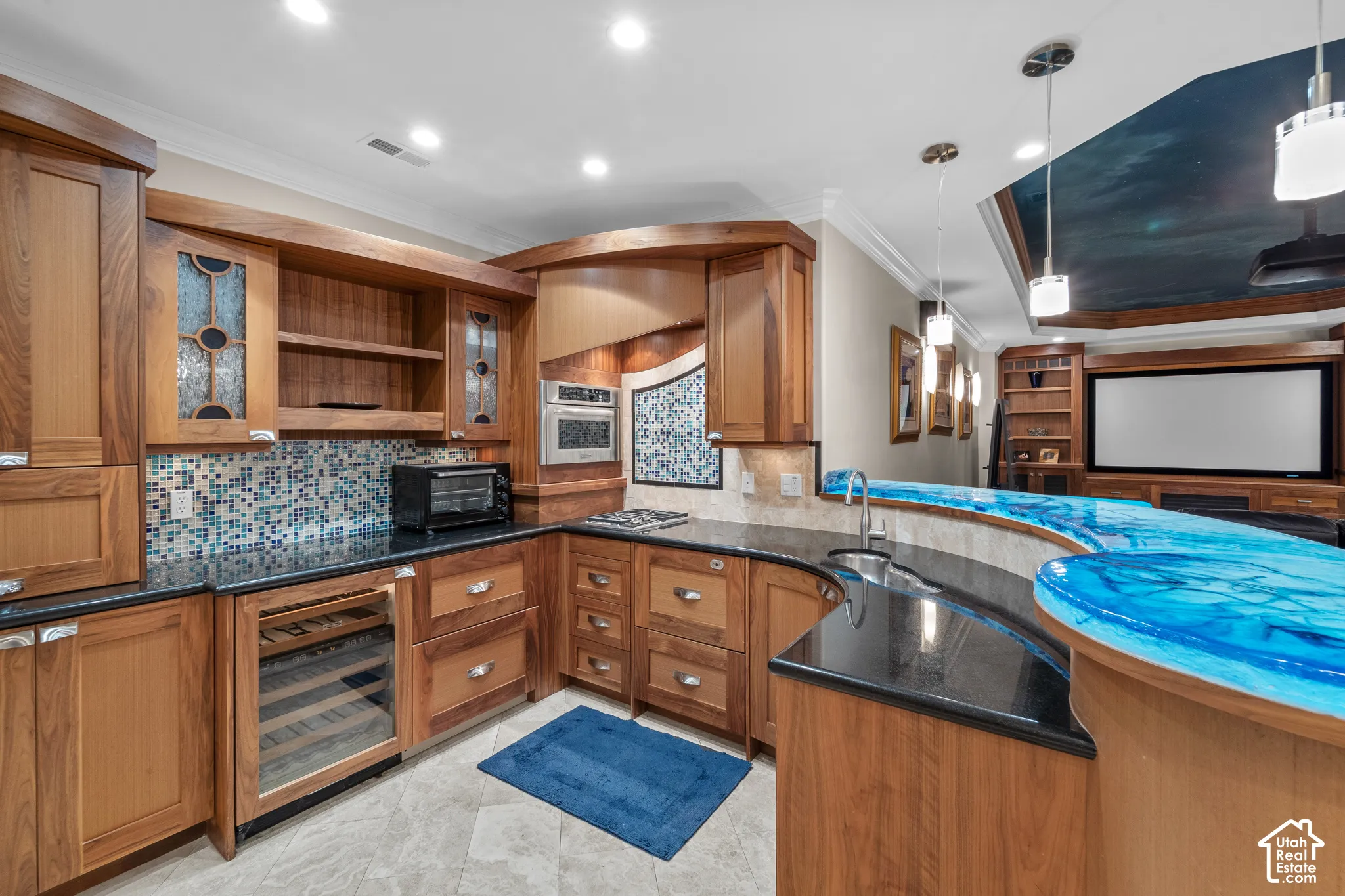 There is so much that went into this kitchenette/ bar. The cabinetry is all custom and made specifically for this space. Everything is soft and rounded. There is a wine fridge, pullout drawer drink fridge, dishwasher, cook top and lots of storage. The bar