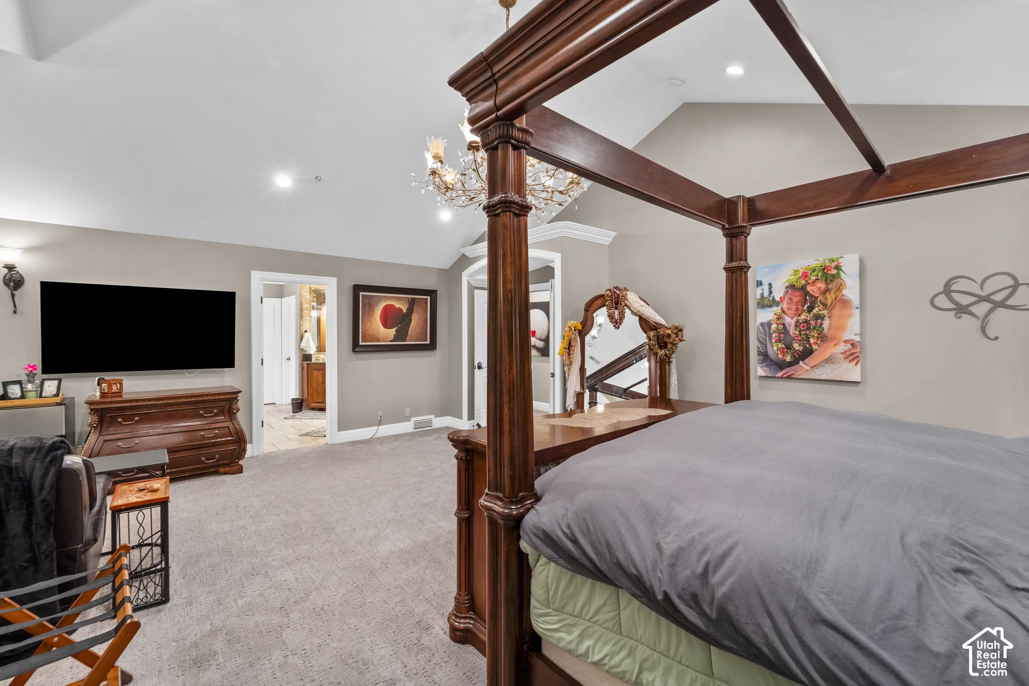 The vaulted ceiling is breathtaking, another WOW feature in this home. The crown molding as you enter the room has up lighting and french doors. From this angle you can also see into the bathroom.