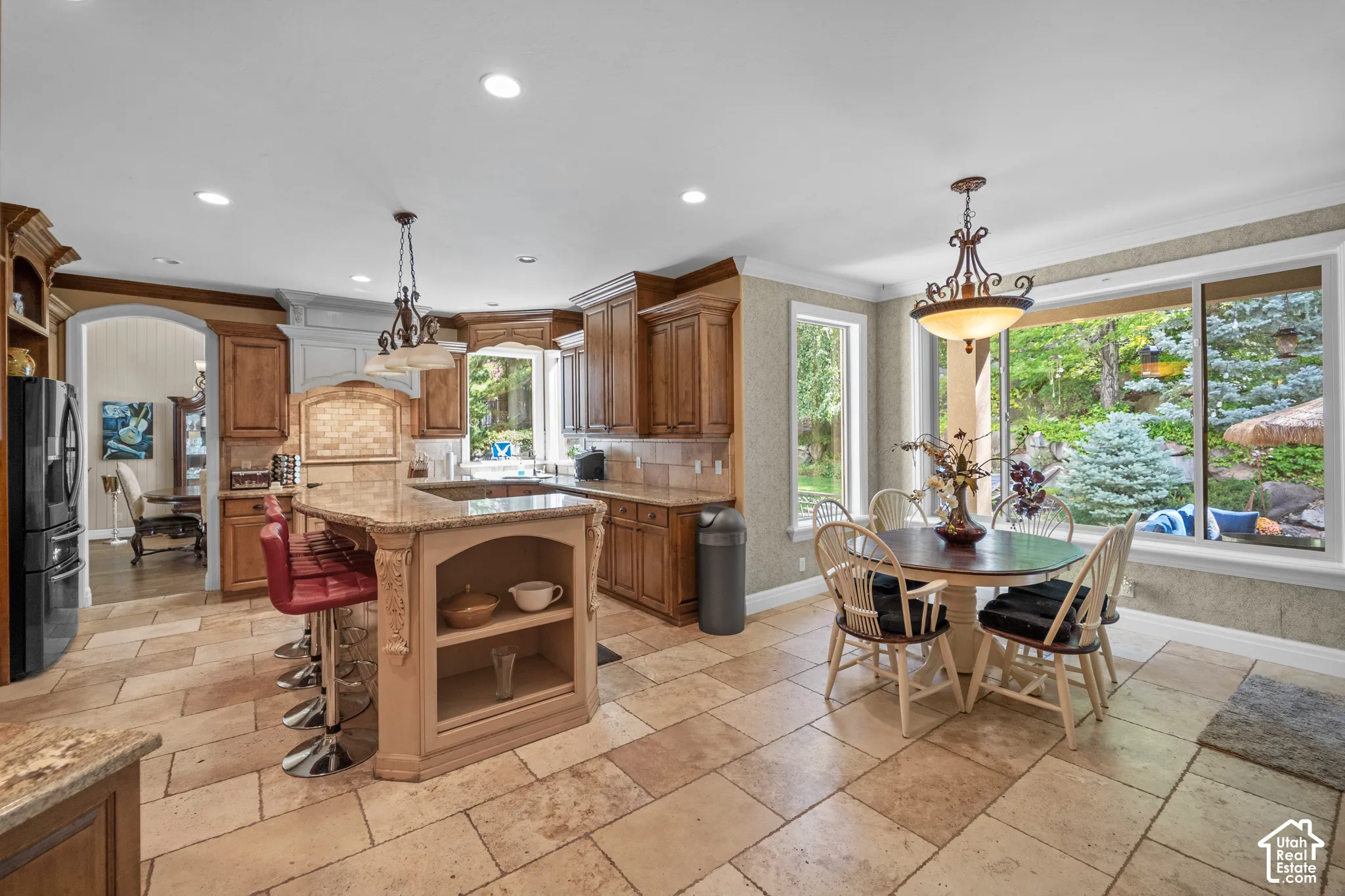 The kitchen spills seamlessly into a breakfast nook, one of Utah's most beautiful backyards and the great room. Abundant natural light. Makes this space perfect night or day.