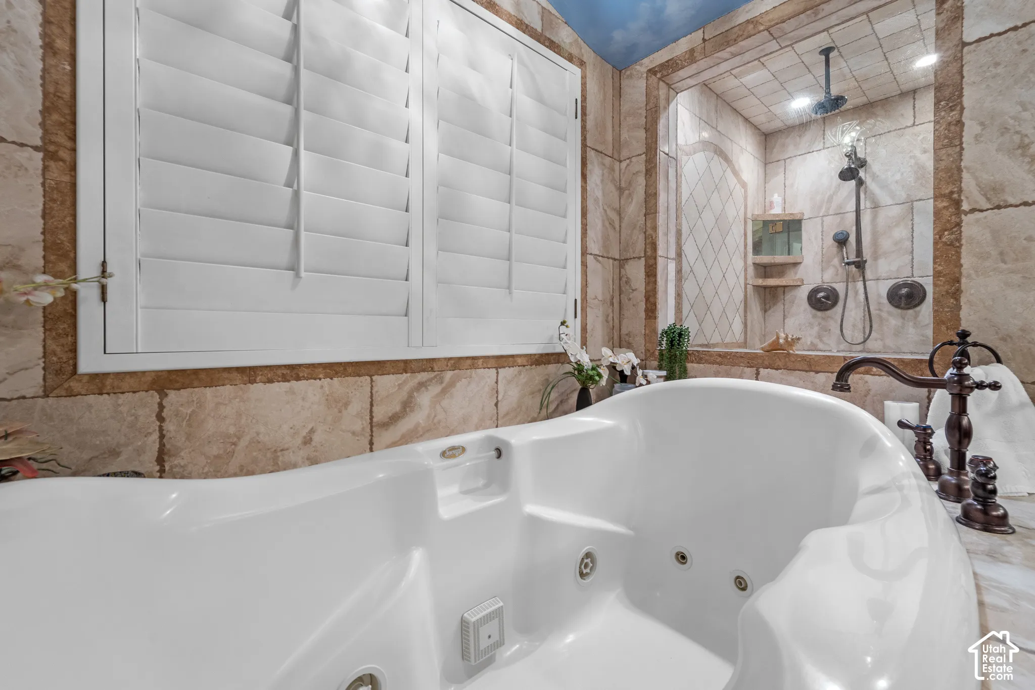 RELAX in the extra deep long tub surrounded by beautiful stone work and a custom painted ceiling.