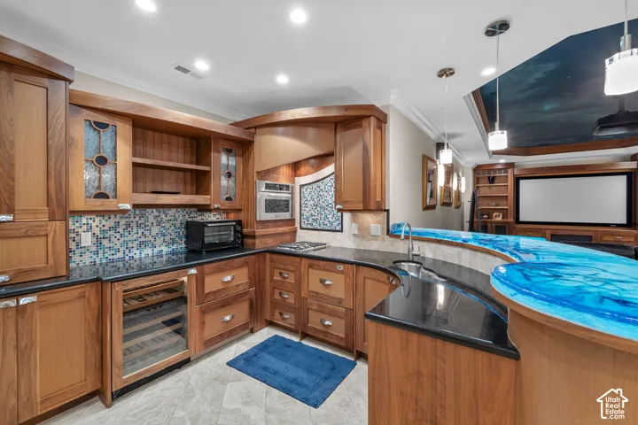 There is so much that went into this kitchenette/ bar. The cabinetry is all custom and made specifically for this space. Everything is soft and rounded. There is a wine fridge, pullout drawer drink fridge, dishwasher, cook top and lots of storage. The bar