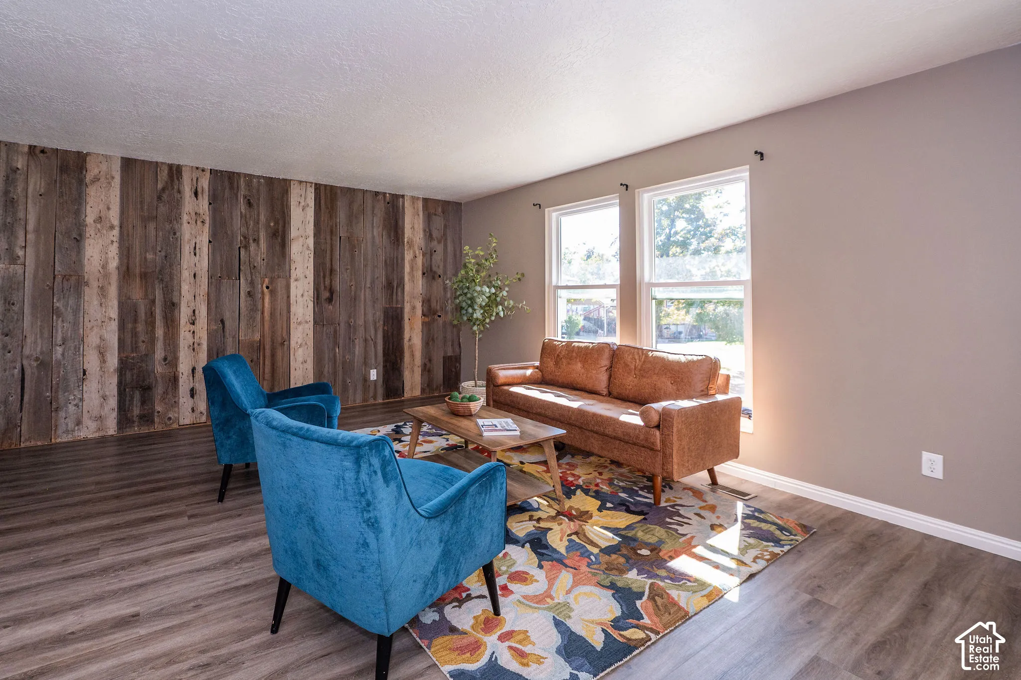Accent wall featuring natural wood paneling, LVP flooring and lots of natural light