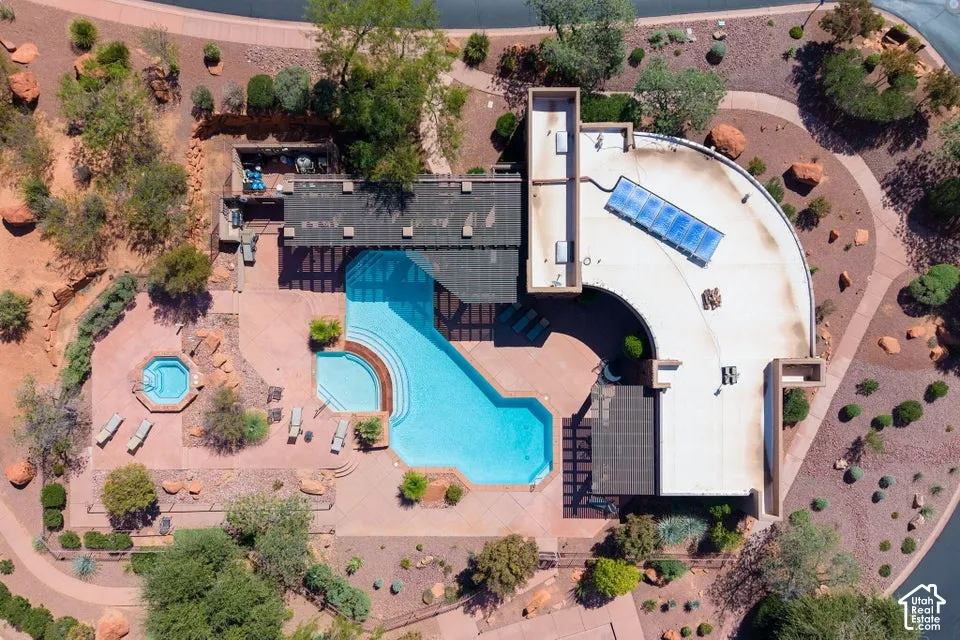Resort-style outdoor area featuring a swimming pool, integrated hot tub, and surrounding paved patio