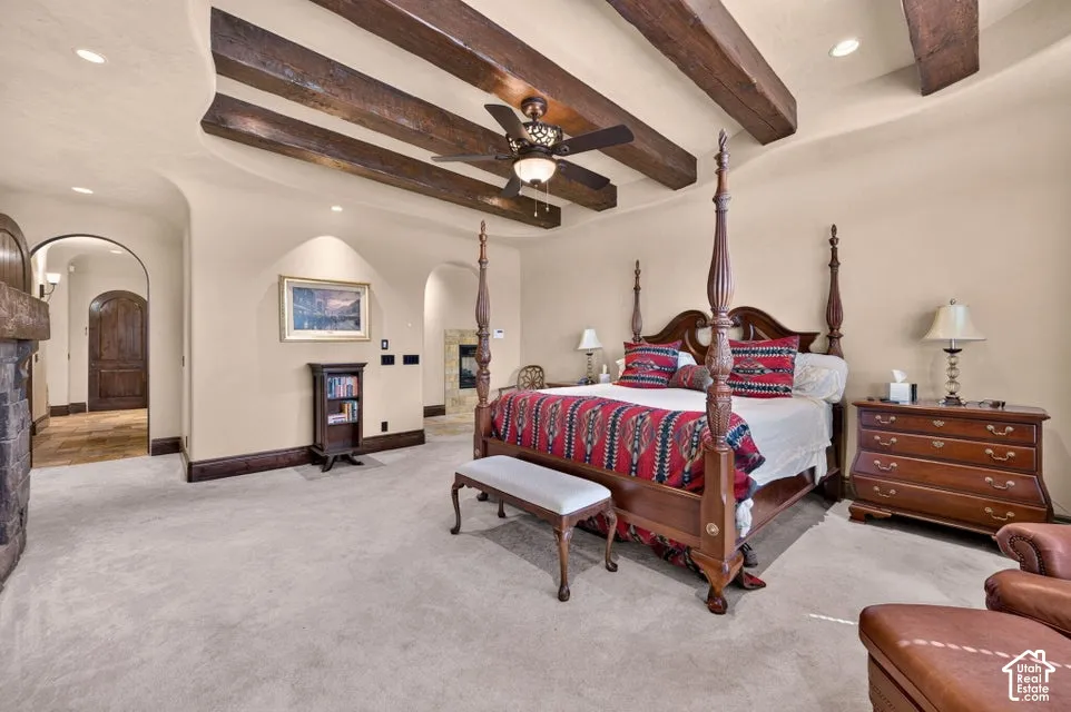 Vaulted ceiling with exposed wood beams, recessed lighting, and a ceiling fan