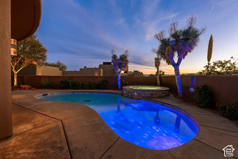 Freeform swimming pool with integrated spa and concrete decking