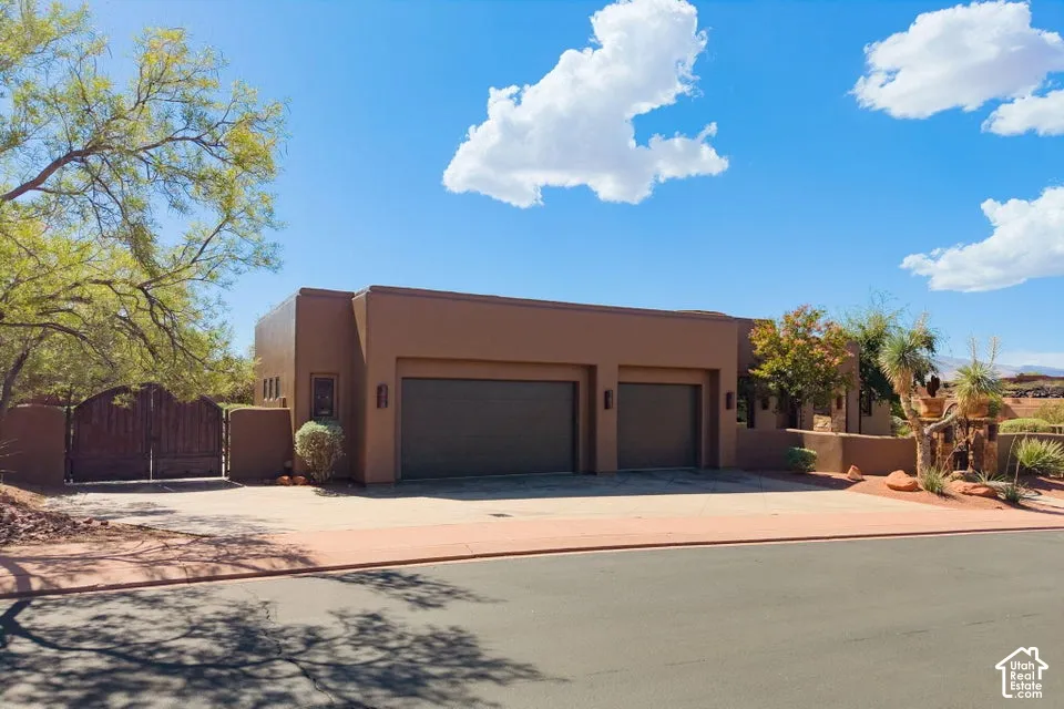 Stucco exterior with a flat roofline, two-car garage, and a gated entry