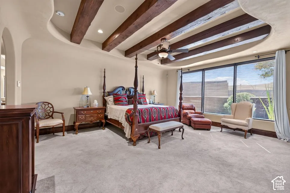Tray ceiling with exposed wood beams, recessed lighting, ceiling fan, and large windows with blinds