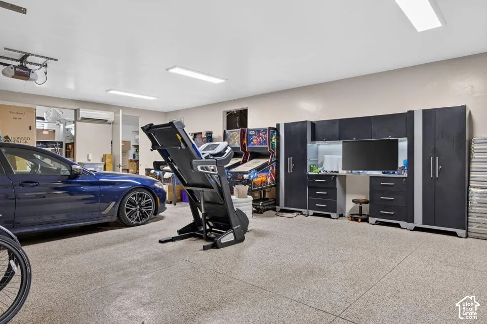 Spacious garage with epoxy flooring, overhead lighting, and built-in cabinetry