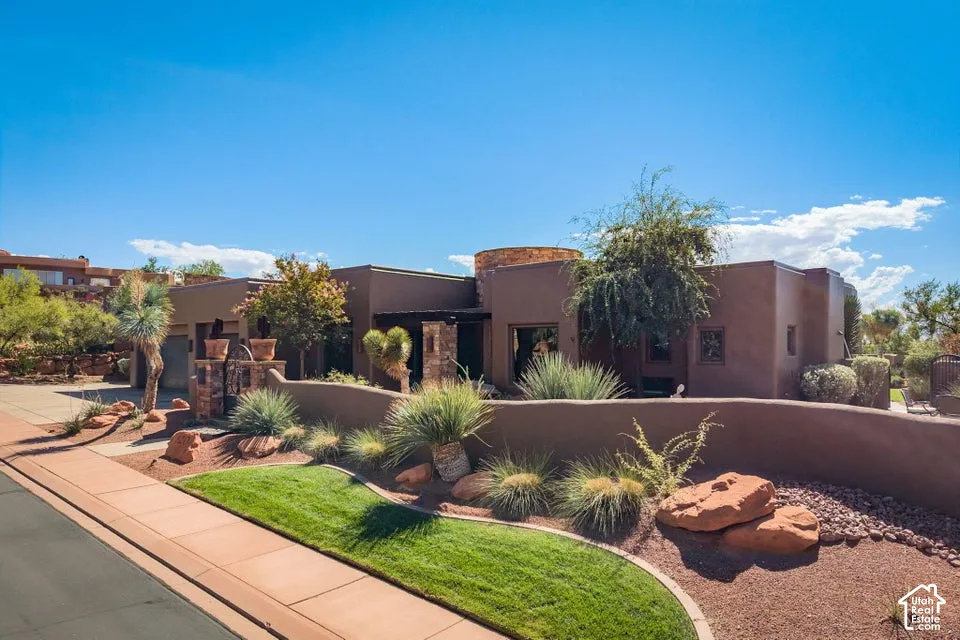 Stucco exterior with stone accents, a multi-level roofline, and desert-adapted landscaping