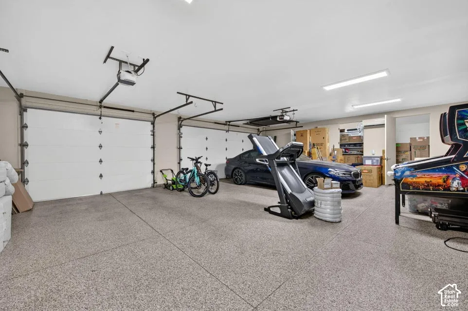 Three-car garage with epoxy flooring, automatic garage door openers, and recessed lighting