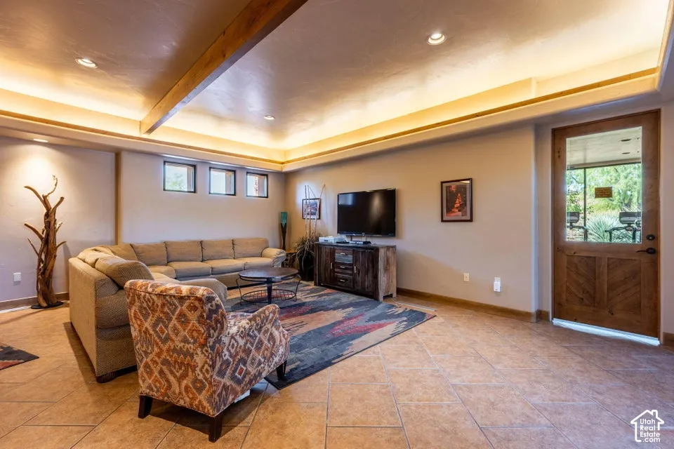 Recessed ceiling lighting, exposed wood ceiling beam, tiled flooring, wood-paneled door with glass insert, and three transom windows