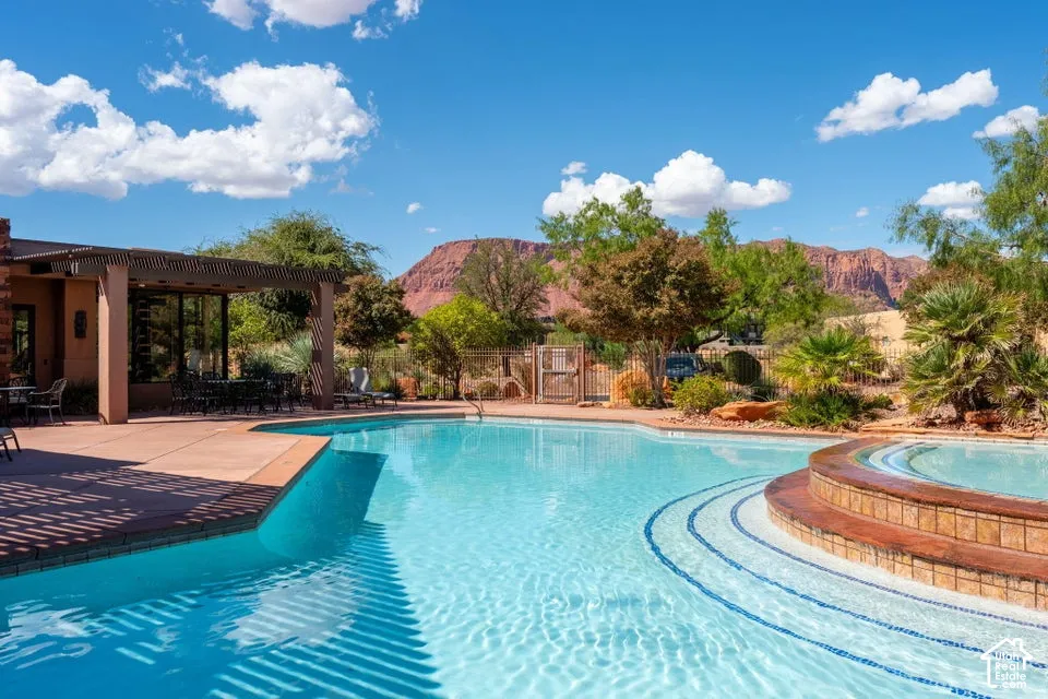 Resort-style pool with integrated spa and decorative tile accents