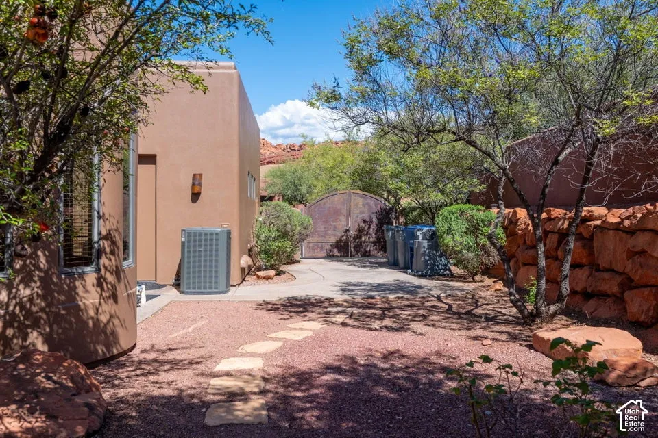 Exterior featuring a stucco finish, a stone accent wall, and a curved concrete pathway