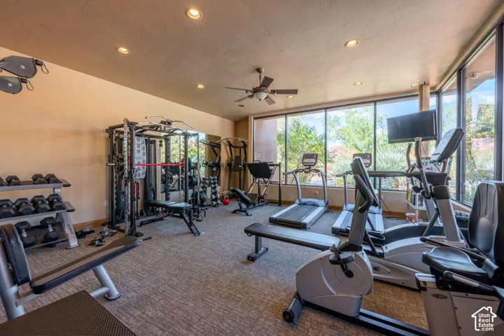 Dedicated fitness room featuring a full wall of windows, recessed lighting, and a ceiling fan