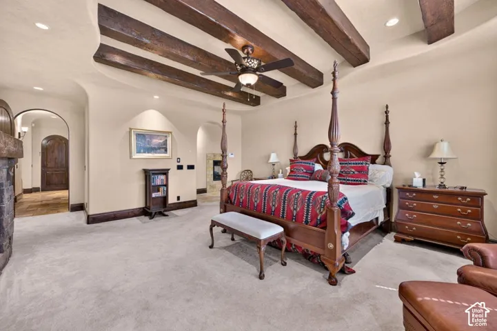 Vaulted ceiling with exposed wood beams, recessed lighting, and a ceiling fan