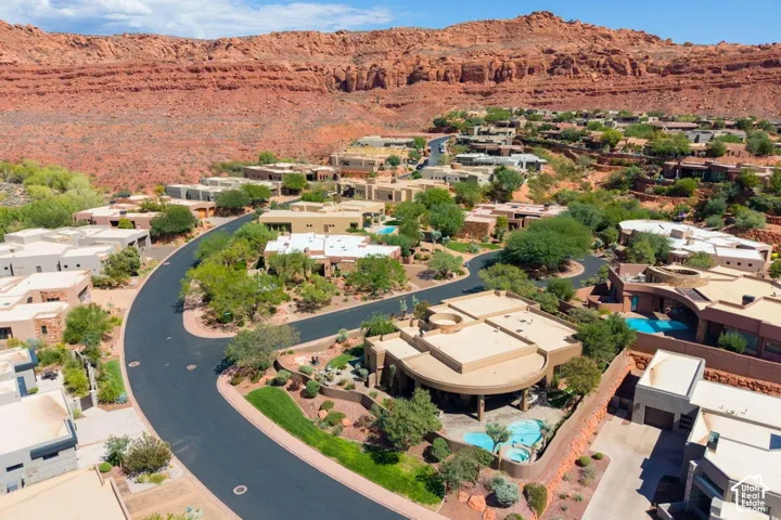 Residential properties with flat roofs, integrated landscaping, and private outdoor pools, set against a mountainous desert backdrop