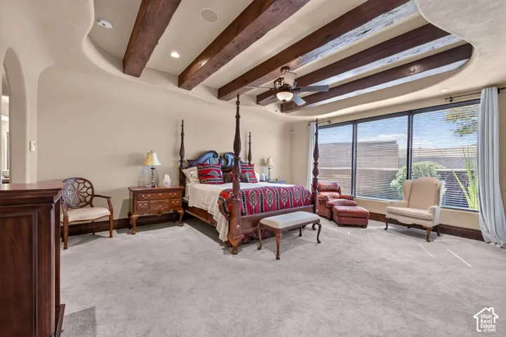 Tray ceiling with exposed wood beams, recessed lighting, ceiling fan, and large windows with blinds