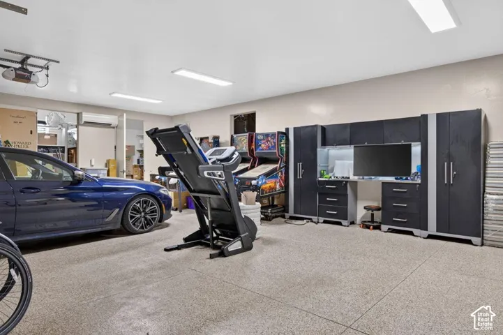 Spacious garage with epoxy flooring, overhead lighting, and built-in cabinetry
