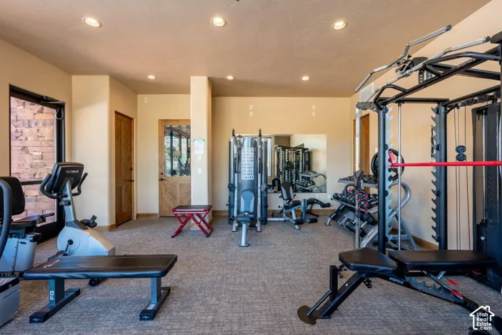 Recessed lighting, wood-finish doors, full-wall mirror, and textured carpet flooring