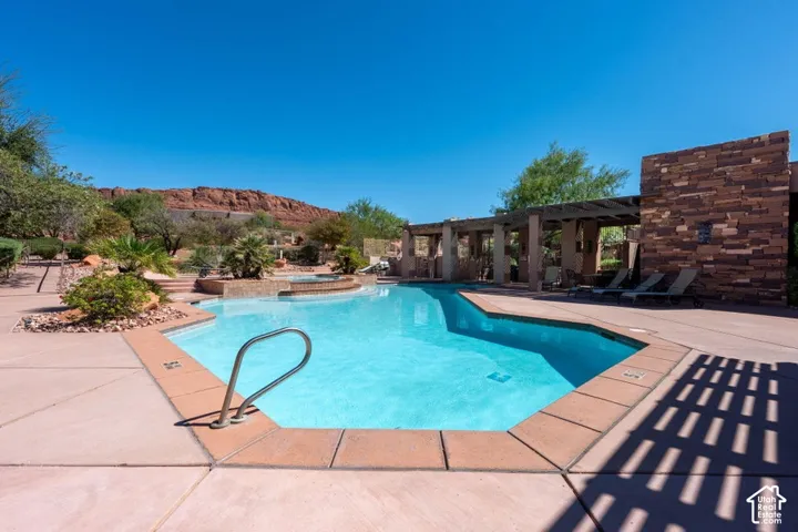Resort-style pool with integrated spa, surrounded by extensive concrete decking