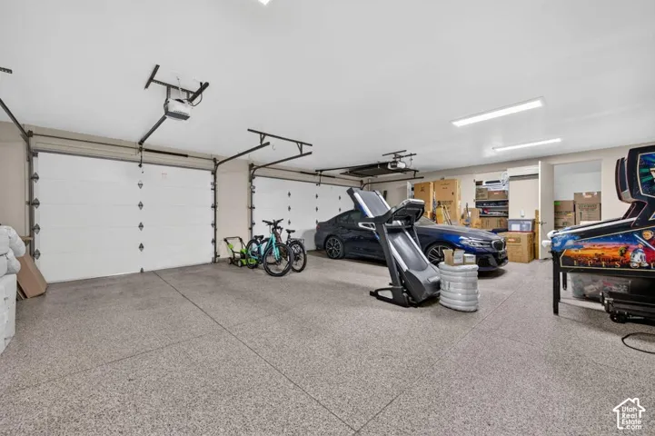 Three-car garage with epoxy flooring, automatic garage door openers, and recessed lighting