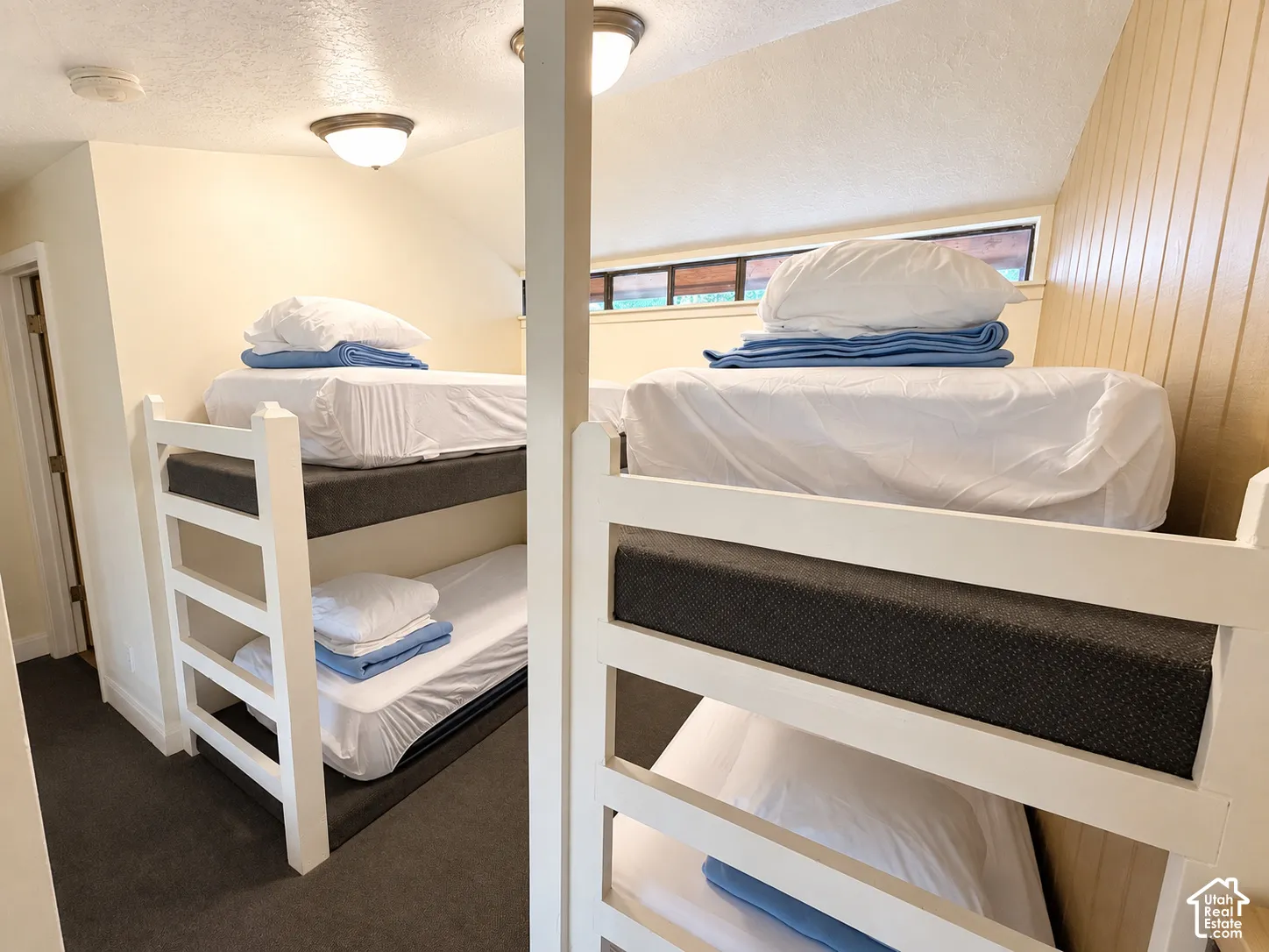 Bunk bed sleeping area featuring white painted wood frames and recessed lighting