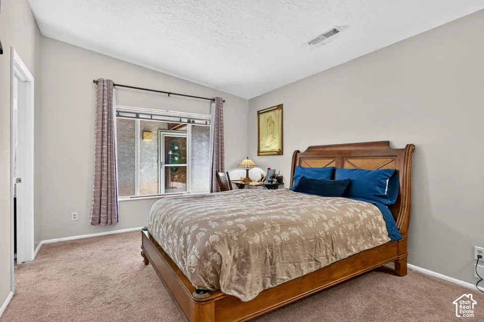 Neutral wall paint, vaulted ceiling, and carpet flooring