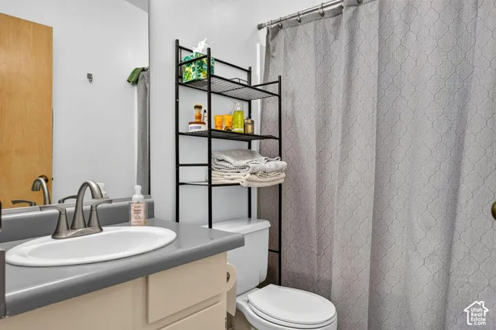 White vanity with a single basin sink, brushed nickel faucet, and a large wall-mounted mirror