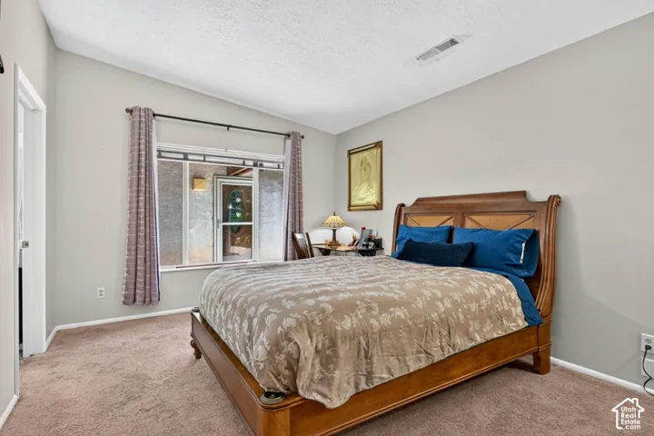 Neutral wall paint, vaulted ceiling, and carpet flooring