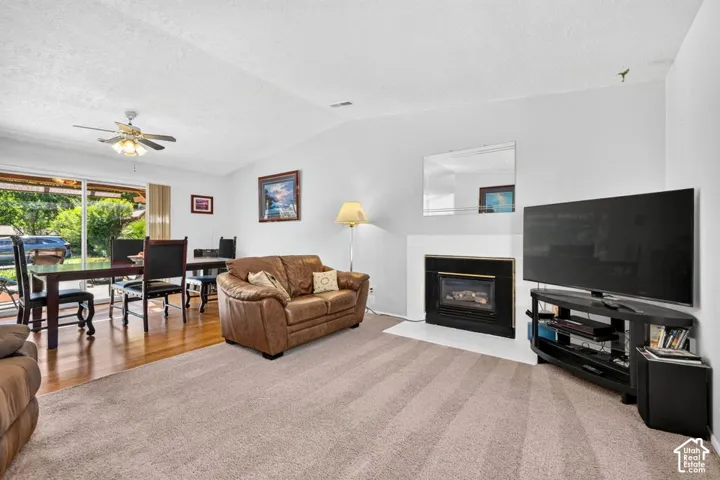 Living area featuring a fireplace with a black surround, a light-colored hearth, and vaulted ceilings