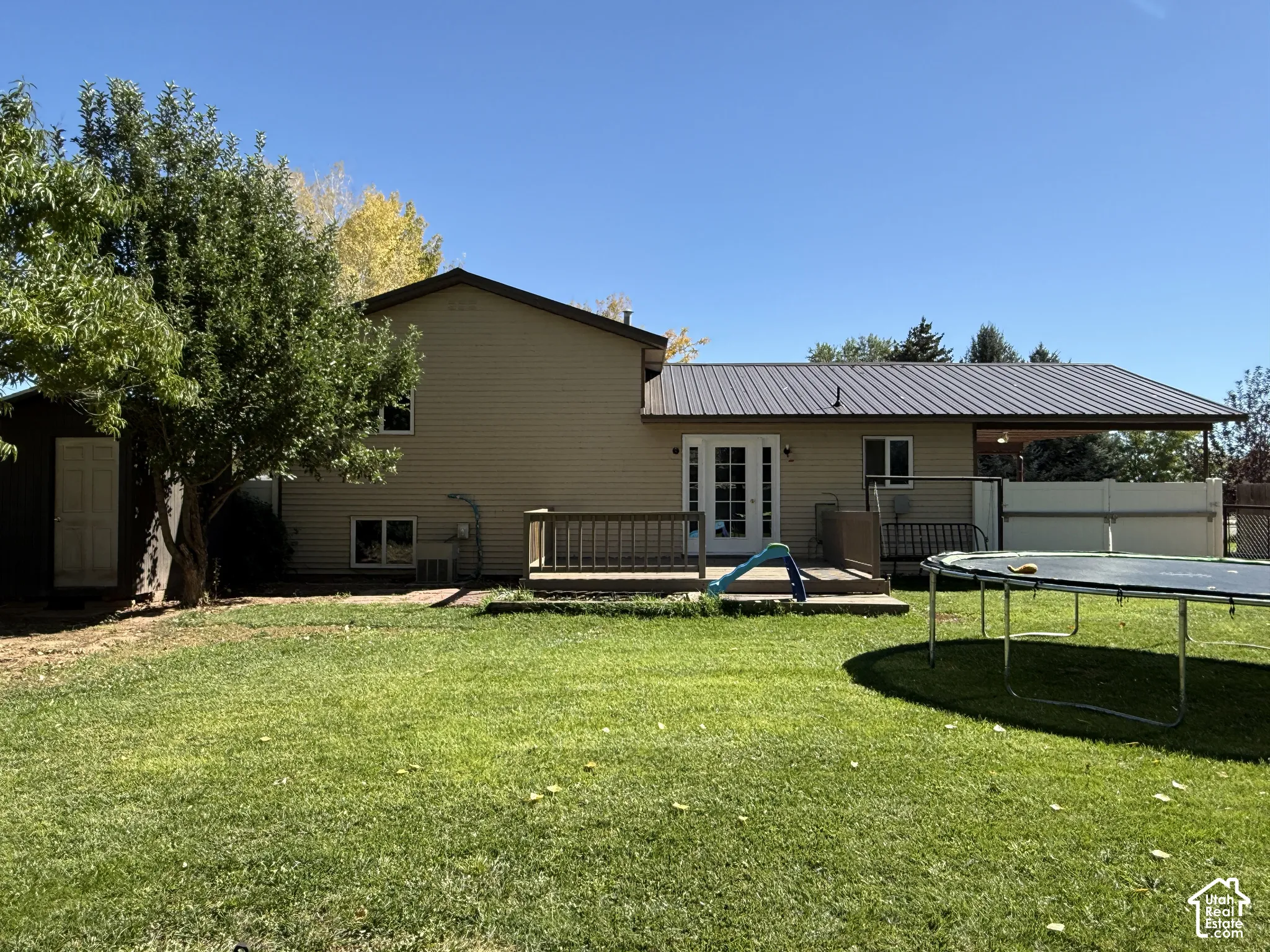 Rear exterior with siding, a metal roof, and a covered patio area