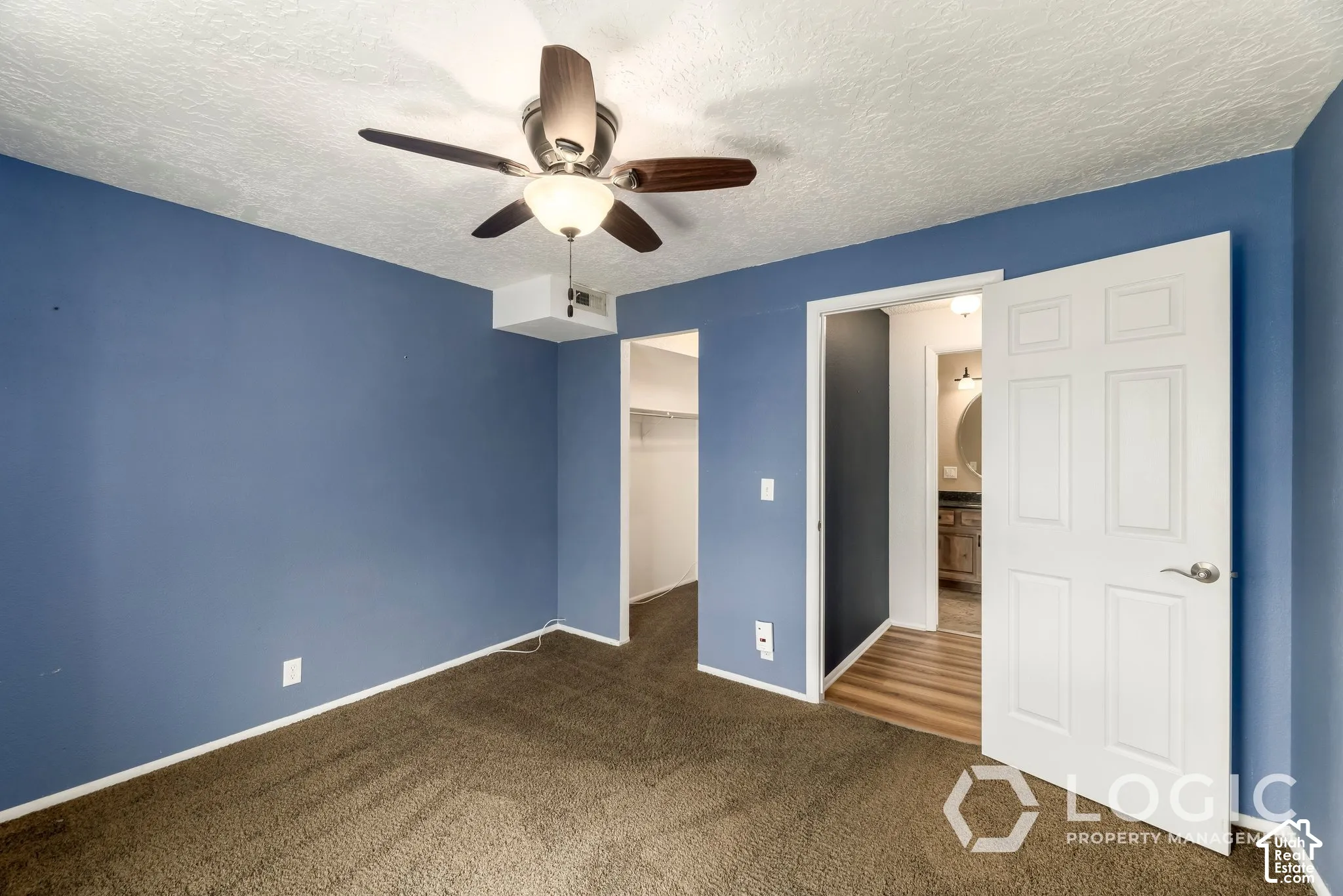 Room featuring a ceiling fan with integrated lighting, brown carpet flooring, and a white six-panel door
