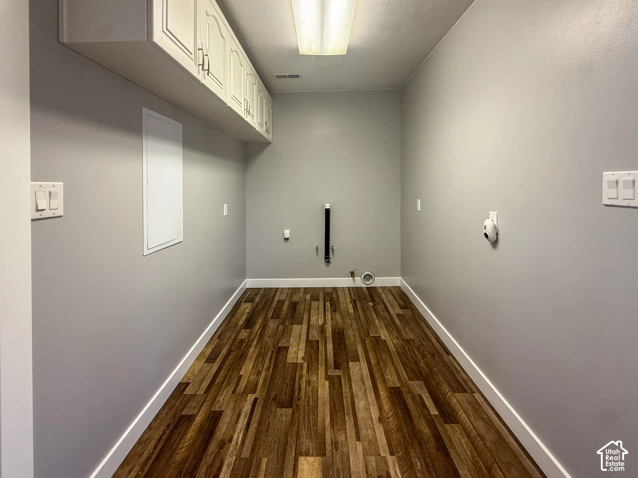 Salon/Mudroom - Wood-finish flooring, overhead cabinetry, and light gray wall paint