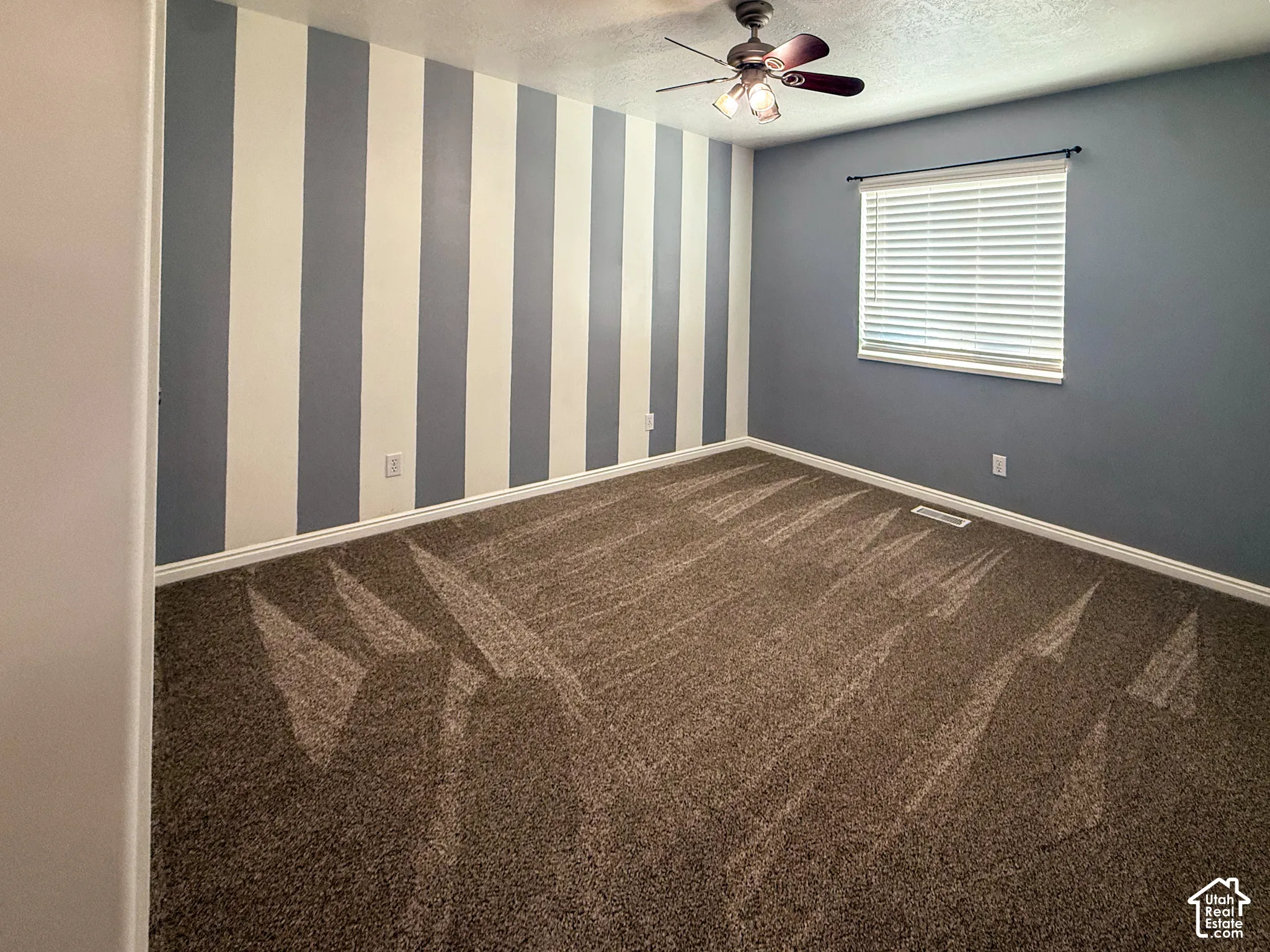 Bedroom 2 - Textured carpeting, a ceiling fan with integrated lighting, and a window with horizontal blinds